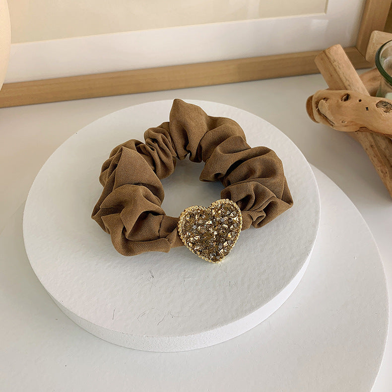 This pretty scrunchie is perfect for the casual but fancy pony tail. Made from soft cloth fabric featuring a beautiful heart full of luminous crystal rhinestones. Can be worn as a bracelet for that "just in case I need to put my hair up" kind of day. This piece is a must have hair accessory Order today and enjoy fast shipping